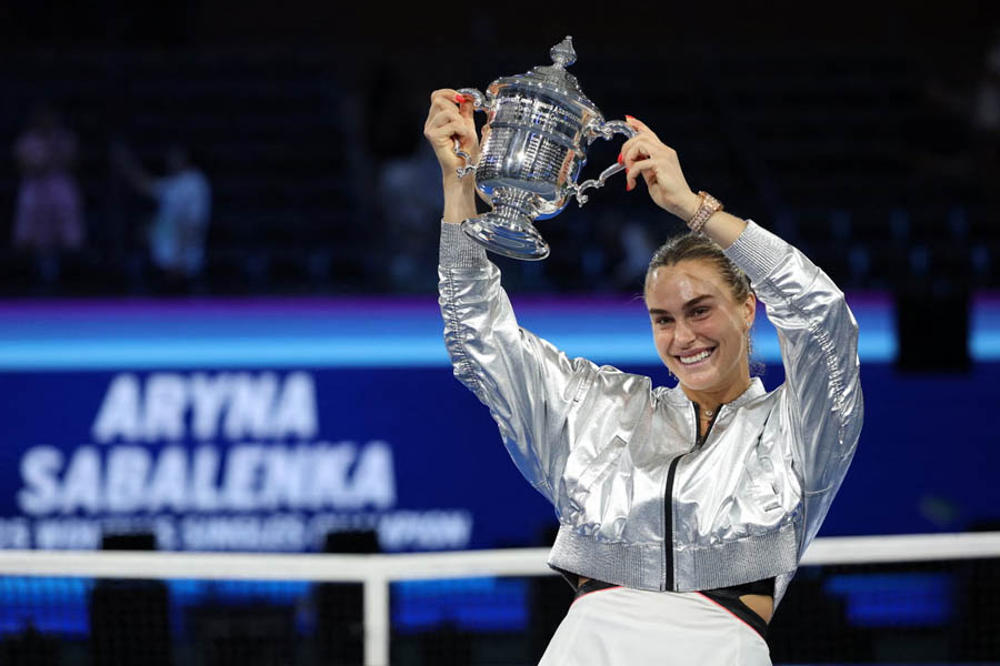 Aryna Sabalenka holding the trophy and celebrating her consecutive US Open women’s singles championship victory in 2025.