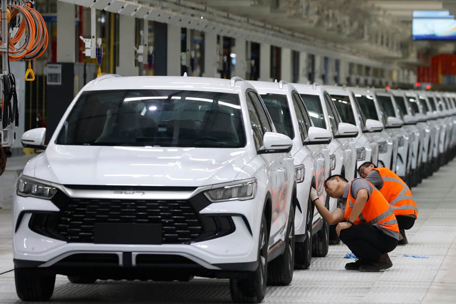 Workers cleaning vehicles at BYD’s manufacturing plant in Camaçari, Brazil, after the company recorded 4.55 million global car sales in 2025.
