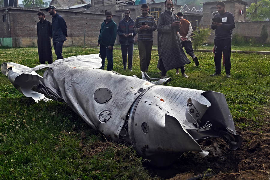 People look at a damaged part of an aircraft in Wuyan, near Srinagar, on 7 May.