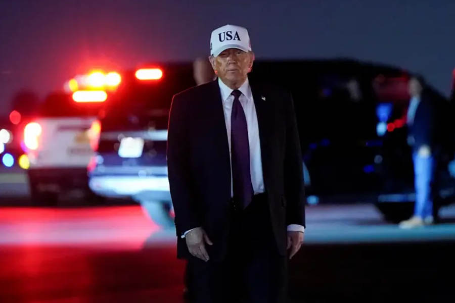 President Donald Trump at Palm Beach International Airport before the announcement of US military strikes, speaking to media on the runway.