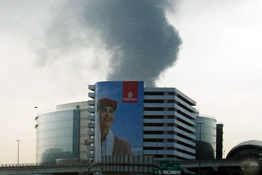 Smoke visible at Dubai International Airport through a vehicle windshield after a drone-related fire incident.