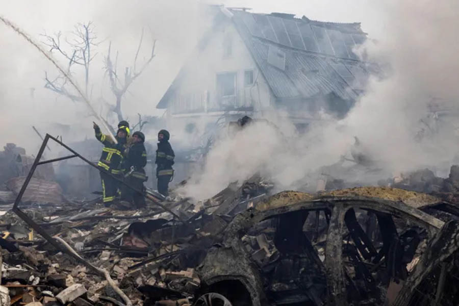 Emergency workers extinguish fires in the debris of a house in the Kyiv region