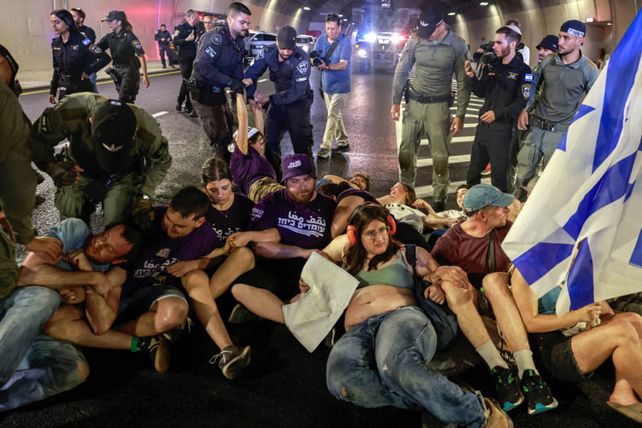 Israeli police officers remove demonstrators blocking traffic in a Jerusalem tunnel during mass protests on Sunday.