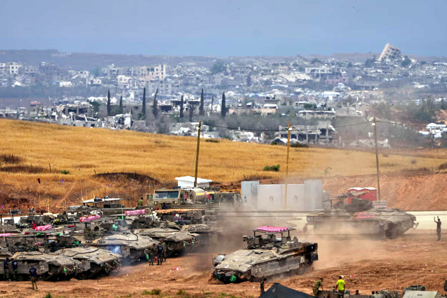 Israeli soldiers work on tanks and armoured personnel carriers near the border with the Gaza Strip, in southern Israel