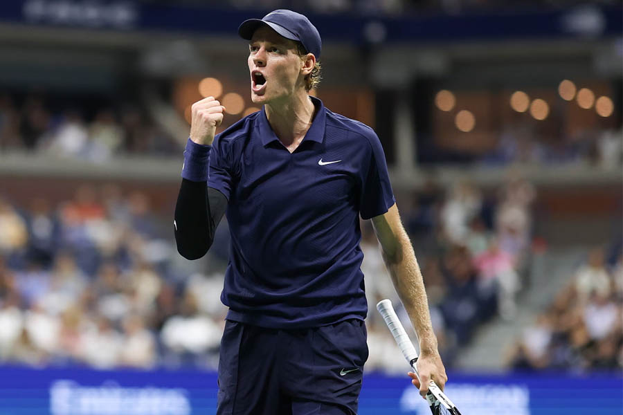 Jannik Sinner cheering and pumping his fist after winning a point against Félix Auger-Aliassime in the US Open semi-finals.