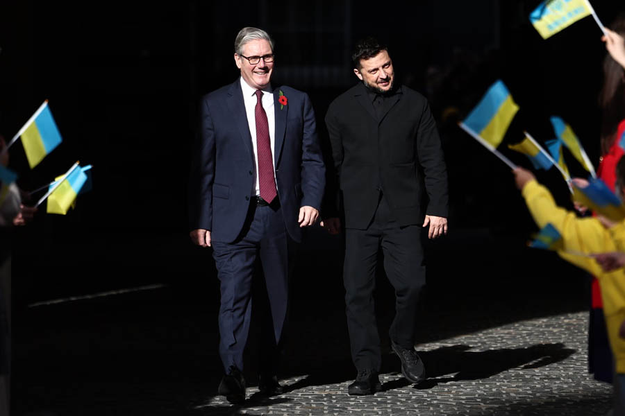 Keir Starmer and Volodymyr Zelenskyy smiling as they are greeted by Ukrainian children outside the Foreign, Commonwealth, and Development Office in London.