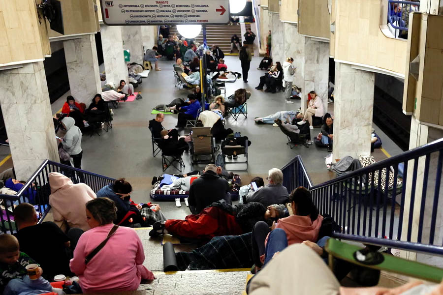 Ukrainian civilians huddled in a Kyiv subway station during Russian missile and drone strikes, some with pets and sleeping bags.