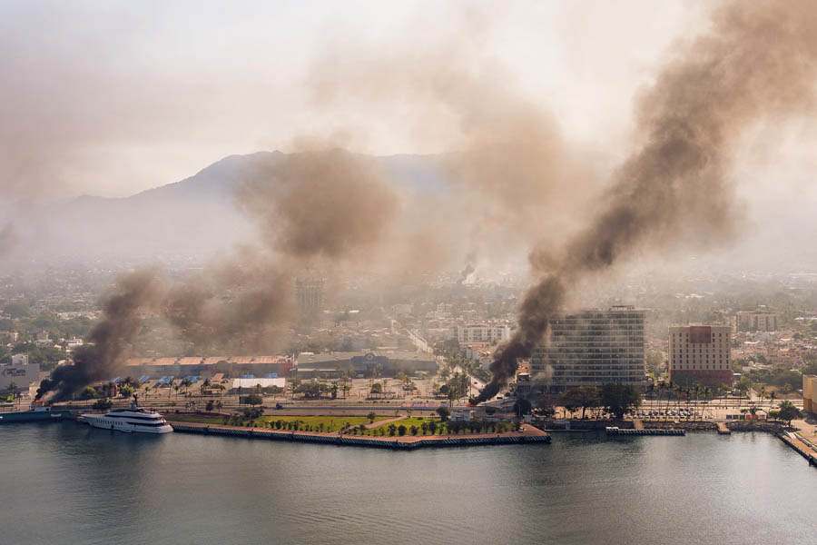 Gunmen blocking a major road with burning cars and buses while engaging in a confrontation with government security forces in western Mexico.