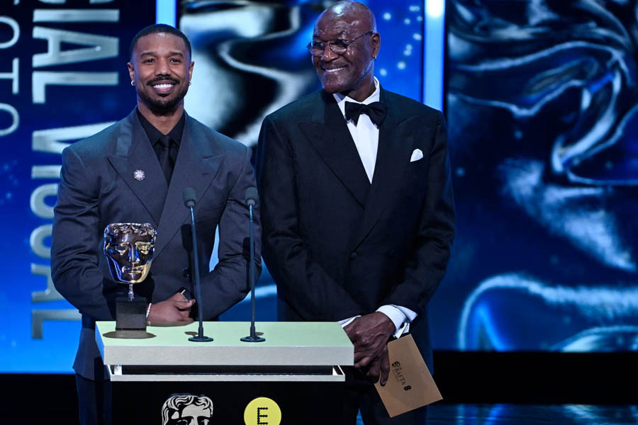 Michael B Jordan and Delroy Lindo standing on stage at the Baftas 2026 while presenting the Special Visual Effects award.