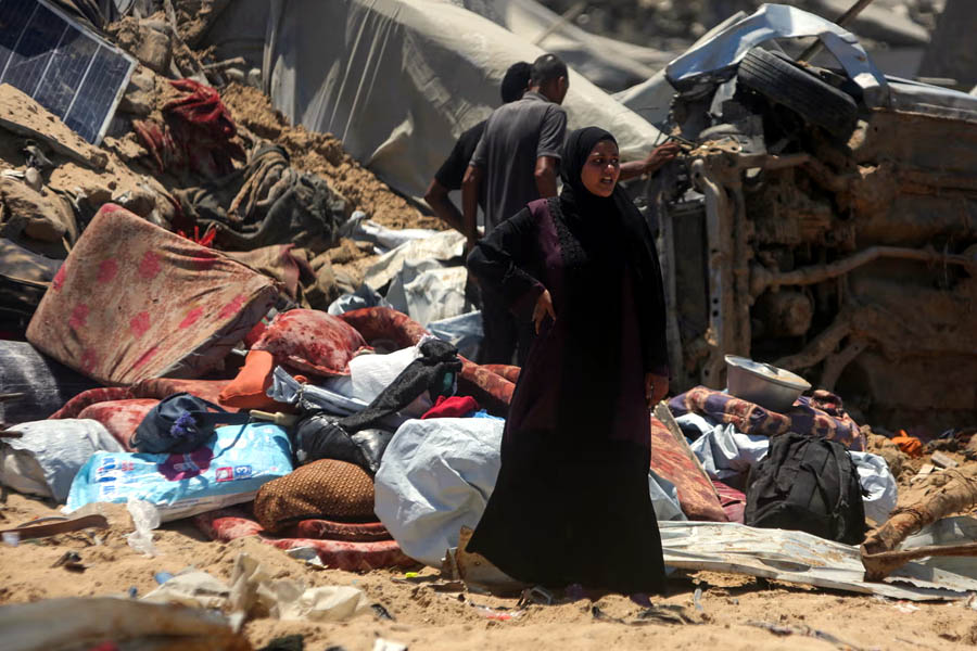 Palestinians retrieve belongings from the rubble after an Israeli tank incursion targeted a displacement camp in Khan Younis, intensifying tensions over the proposed Gaza humanitarian city.
