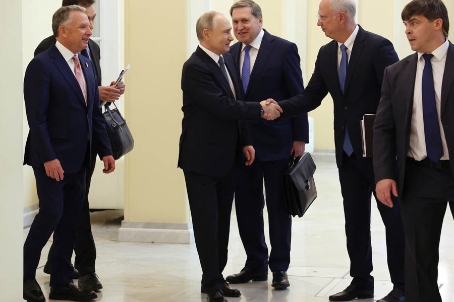 Russian president Vladimir Putin seated with US special envoy Steve Witkoff during a diplomatic meeting.