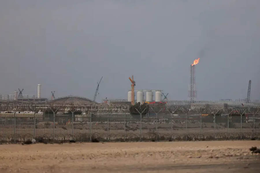 Fire and emergency response at Ras Laffan gas facility in Qatar after missile strike, showing flames, industrial structures, and crews working to control the blaze