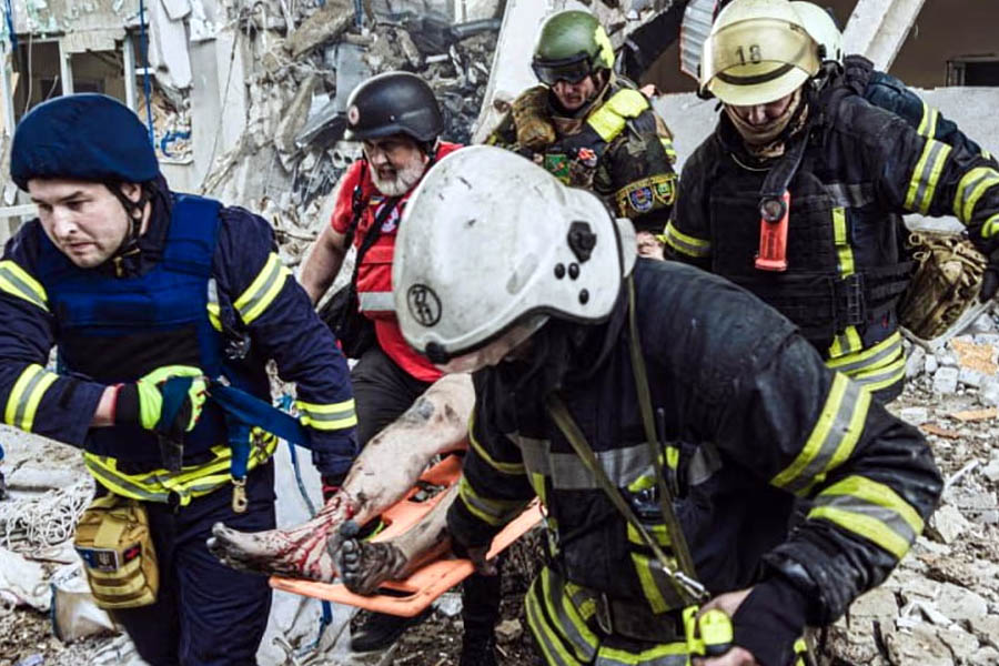Ukrainian emergency workers rescue a victim of Russian attacks on Kharkiv.