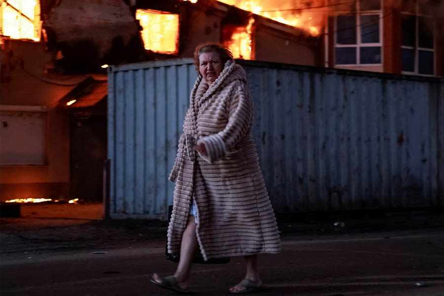A woman walking past a burning house in Brovary in Ukraine’s Kyiv region following a Russian missile and drone attack.
