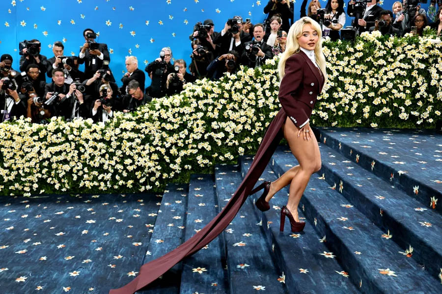 Sabrina Carpenter attributes her lack of trousers to Pharrell Williams, who refused to make them given her diminutive stature. That didn’t stop him adding elongated tux tails to her coffee-coloured and tightly tailored jacket.