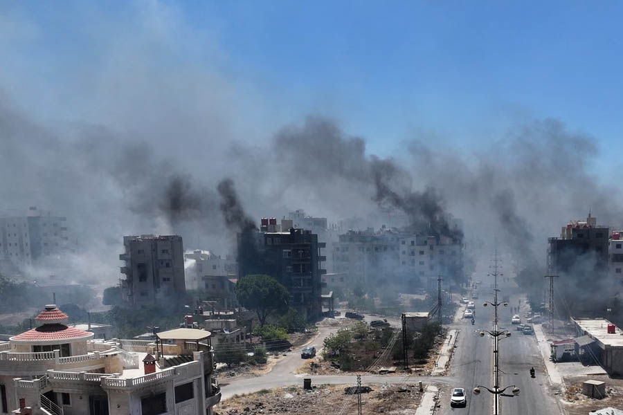 Smoke rises over the city of Sweida as Syria declares a comprehensive ceasefire following a week of deadly clashes that killed over 700 people.