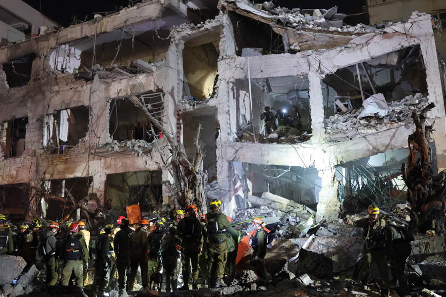 Israeli emergency responders and firefighters working at the scene of a damaged building in Tel Aviv following an Iranian missile strike.