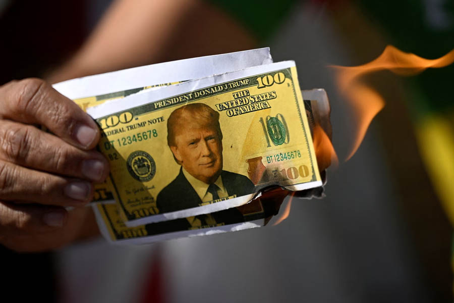 A protester in Brasília, Brazil, burns a mock dollar bill with Donald Trump’s face as global backlash grows over Trump’s sweeping new trade tariffs.