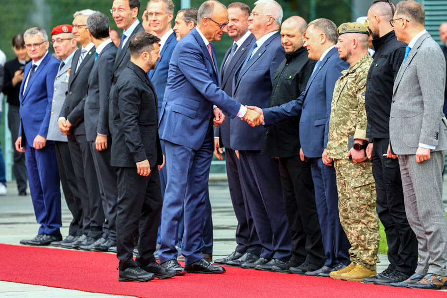 Friedrich Merz shakes hands with members of the Ukrainian delegation alongside Volodymyr Zelenskyy in Berlin.