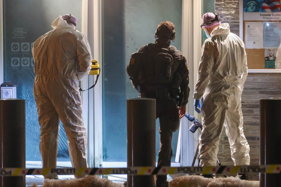 Police officers investigating the blast site outside the United States Embassy in Oslo, Norway, following a suspected bombing incident.